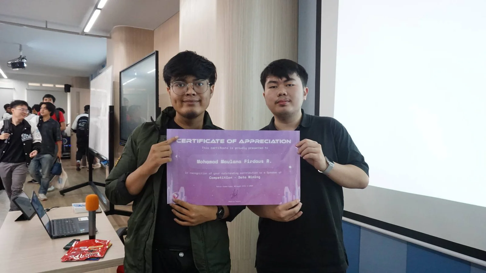 Berfoto bersama penyelenggara sambil memegang sertifikat apresiasi pembicara kompetisi data mining