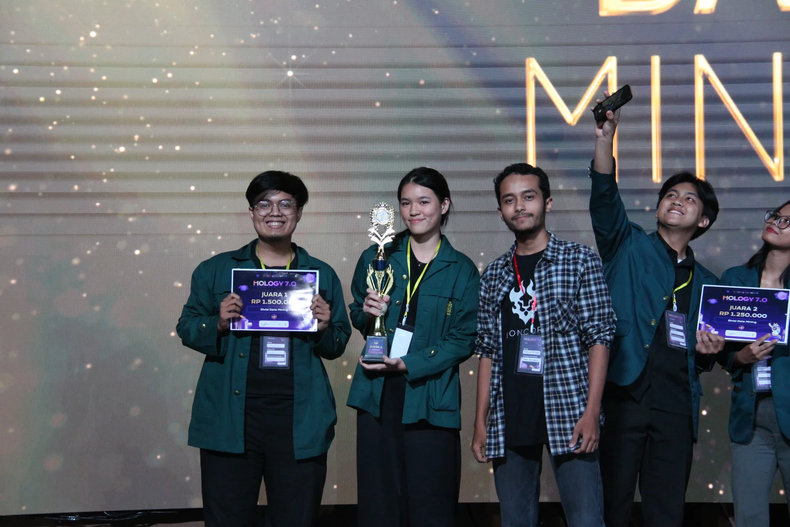 Foto di panggung bersama penerima penghargaan, memegang plakat juara pertama Data Mining dan piala
